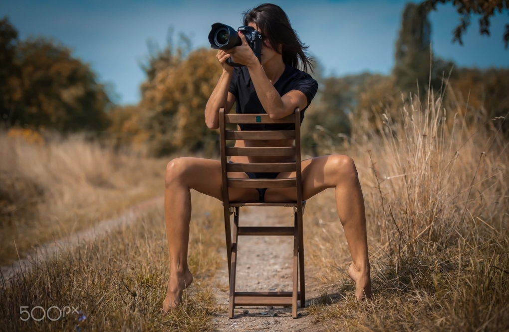 Брюнетка с фотоаппаратом ню